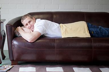 Man relaxing at home using Biothermored moist heat pad for back pain 